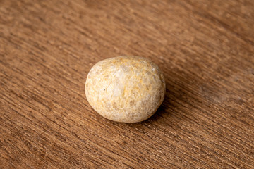 Round small gravel of sandstone washed round by the waves of the sea on wooden underground