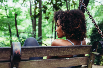Rear view of woman on park bench swing