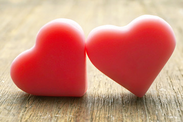 Fototapeta premium Couple pink love hearts lay against together on wood table.