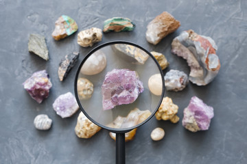 Set from mineral stones, Top view. Fluorite and magnifying glass in the foreground and in focus.