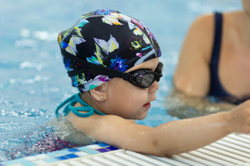 Little girl in googles in the swimming pool