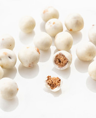 Exclusive handcrafted white chocolate candy with nut. Luxury handmade bonbon on white marble background. Product concept for chocolatier