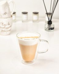 Glass cup of Hot art Latte Coffee on white table in Coffee shop. Sweet drink with milk