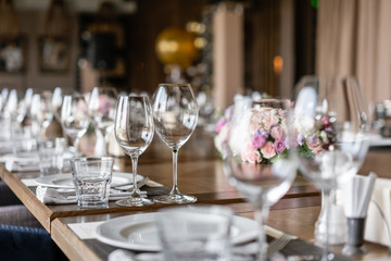 Wine glasses in the foreground. Wedding Banquet or gala dinner. The chairs and table for guests, served with cutlery and crockery.