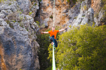 A man sits on a stretched sling.