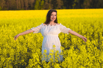 Naklejka na ściany i meble Happy pregnancy, arms outstretched, Smiling pregnant woman with belly in nature