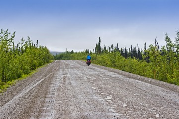 Solitary bicyclist pedals along the Dempster Highway