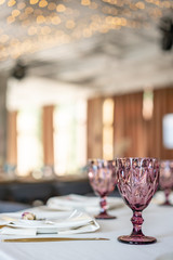 luxury dinner Banquet in the restaurant. Beautiful and exquisite decoration of the wedding celebration. Banquet served table with a beige pink tablecloth, plates and candlesticks with candles.