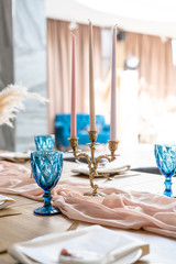 luxury dinner Banquet in the restaurant. Beautiful and exquisite decoration of the wedding celebration. Banquet served table with a beige pink tablecloth, plates and candlesticks with candles.