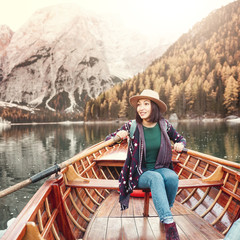 Asian girl sailing by boat on the mountain lake Braies in the Dolomites Alps. The concept of solo travel, search for new experiences and inspiration for life
