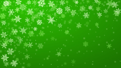 Christmas background of complex blurred and clear falling snowflakes in green colors with bokeh effect