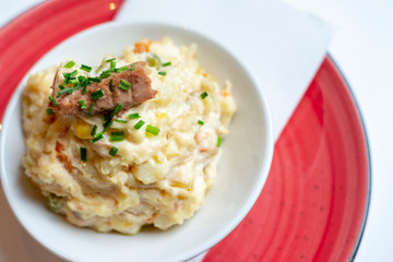 Spanish potato salad on red plate.