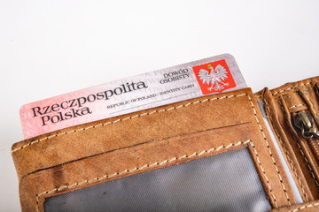 Leather wallet and ID card on a white table. Personal documents in leather cover.