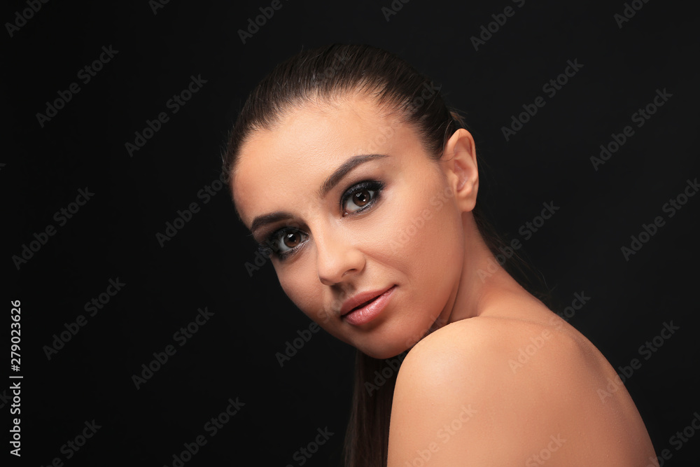 Wall mural beautiful young woman with eyelash extensions on dark background