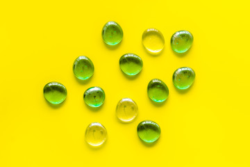 Glass stones for design and home creativity on yellow background top view