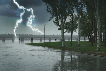 Empty city embankment under heavy rain with lightnings. Thunderstorm