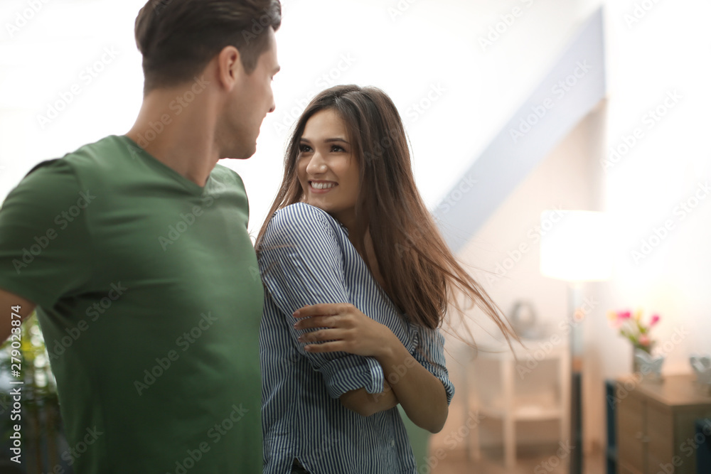 Wall mural beautiful young couple dancing indoors