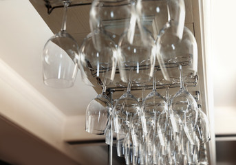 Set of empty clean glasses on bar racks