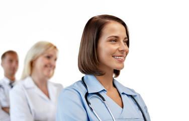 healthcare, medicine and profession concept - smiling female doctor or nurse in uniform over white background