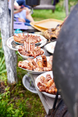 Sausages made on a barbecue lie in the plates, outdoor recreation