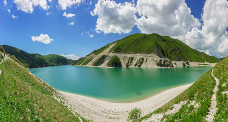 Naklejka na ściany i meble Formed as a result of the collapse during the earthquake, the high-mountain lake Kezenoi am is the largest lake in the area of the Chechen Republic and the Greater Caucasus . Sunny day