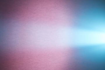 Light turquoise ray of light crosses a light blue smooth and dark pink textural background