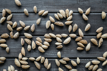 Almond on wooden background top view pattern