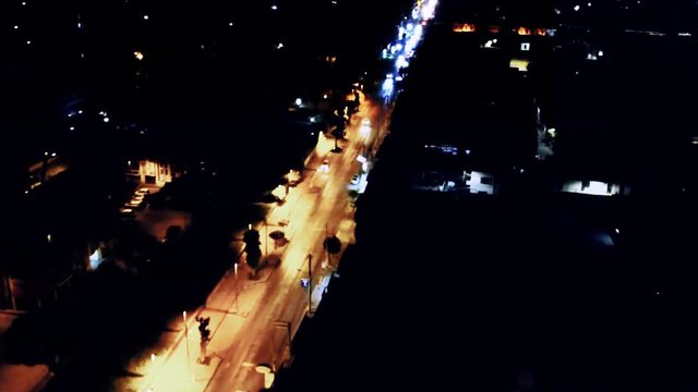 Aerial wide avenue transforms from the well lite orange of the street lighting to the blue of only car lights Aversa, Teverola, Province of Caserta,  Campania, Italy Concept: light to dark,transform