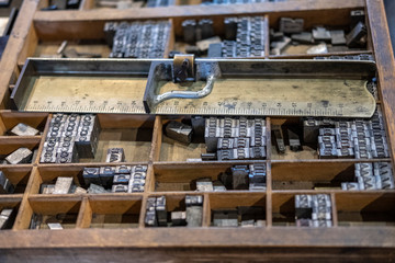 Movable type letterpress for printing. Wooden drawer containing tools and letter blocks.