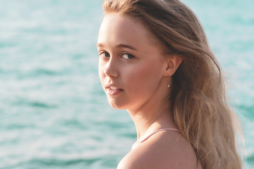 Naklejka premium young slim beautiful woman in pink bikini on tropical beach. Portrait of happy young woman smiling at sea. Girl in swimwear enjoying and walking on beach.