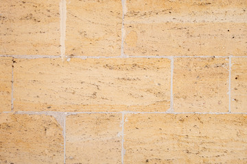 The building is made of natural sandstone. Brick wall.