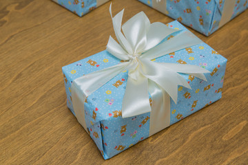 Gift, isolated on wooden background .Group of blue gift boxes with silver ribbons isolated on white background with clipping path . Blue gift boxs with a white ribbon and bow .