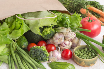 Healthy food in paper bag of different  vegetables on white background. Top view.