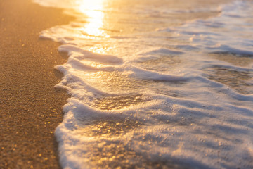 Foam from the sea water on the coast of the beach at sunset day