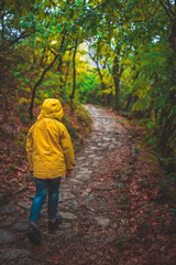 Girl in yellow jacked walking in woods