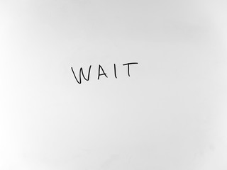 written in marker by hand text wait
