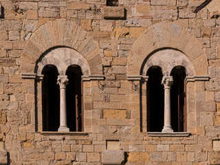 mullioned windows on the wall of a medieval building in Tuscany, Italy