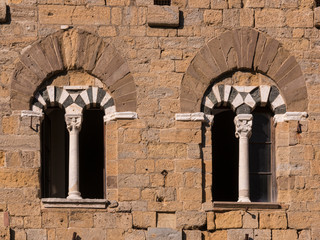 mullioned windows on the wall of a medieval building in Tuscany, Italy