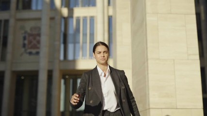 Slow motion shot of anxious young businesswoman reading bad news message on cell phone and running down street with worried facial expression