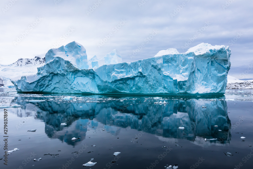 Wall mural impressive iceberg with blue ice and beautiful reflection on water in antarctica, scenic landscape i