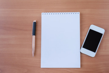 White notepad notepad with pen and phone.