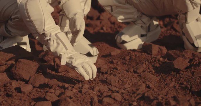 Astronauts collecting rock samples on Mars