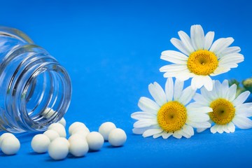 Chamomile flower laying next to a bottle