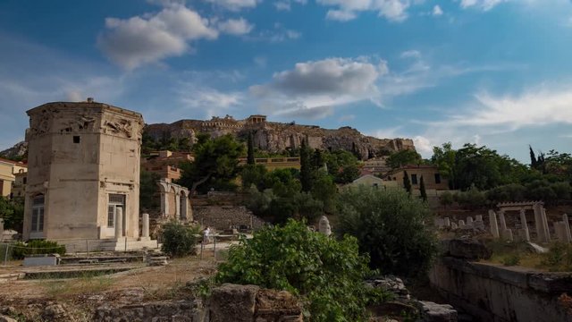 Tourists visiting tower of the winds in Greece under cloudy sky