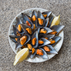 Composition of a plate of delicious mussels with stone background