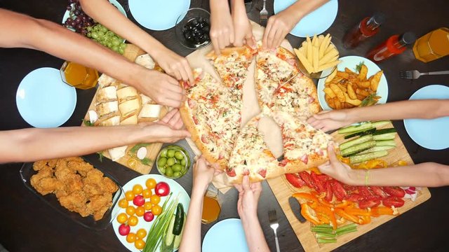 concept of family leisure and eating. top view of people at a large table eating together