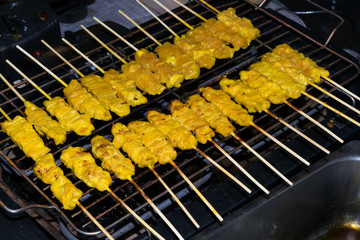 Thai pork satay, grilled pork onto wooden sticks on stove.