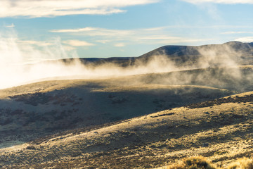 Amazing view of golden sunlight shinning on sea of fog and cloud above the golden yellow dried glass hill in autumn south Patagonia, Chile and Argentina, most iconic beautiful tourism place