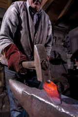 blacksmith manually forging the molten metal