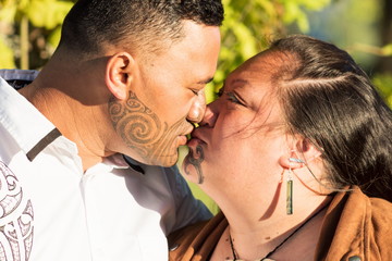 Fototapeta premium Portrait of an attractive Maori couple kissing taken outdoors